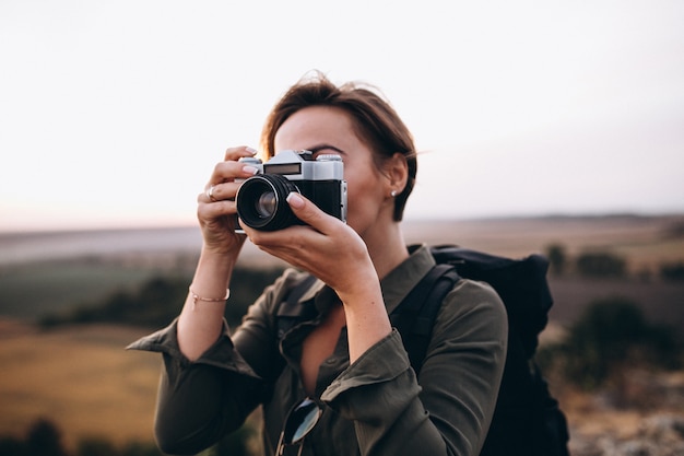 Mujer haciendo senderismo en las montañas y haciendo fotos.