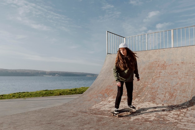 Mujer haciendo trucos de patineta junto a un lago