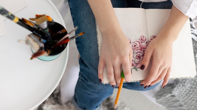 Mujer haciendo un tutorial de dibujo con su teléfono en casa