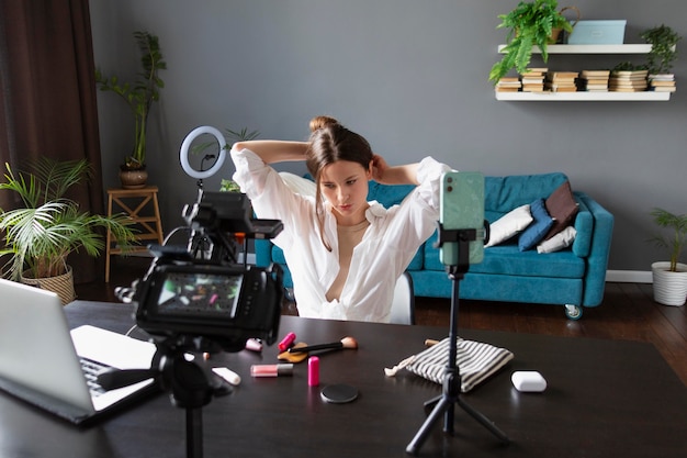 Mujer haciendo un vlog de belleza con su cámara profesional