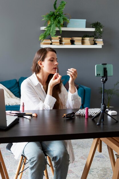 Mujer haciendo un vlog de maquillaje con su smartphone