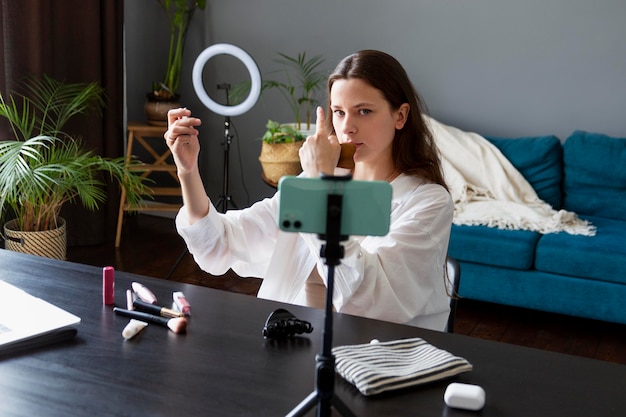 Mujer haciendo un vlog de maquillaje con su smartphone