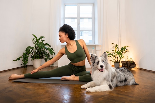 Mujer haciendo yoga acompañada de su mascota