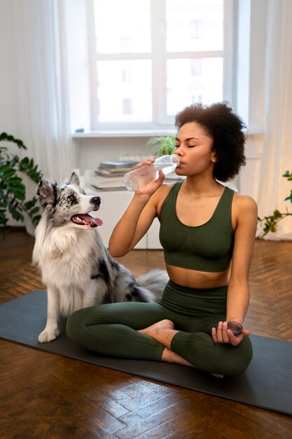 Mujer haciendo yoga acompañada de su mascota