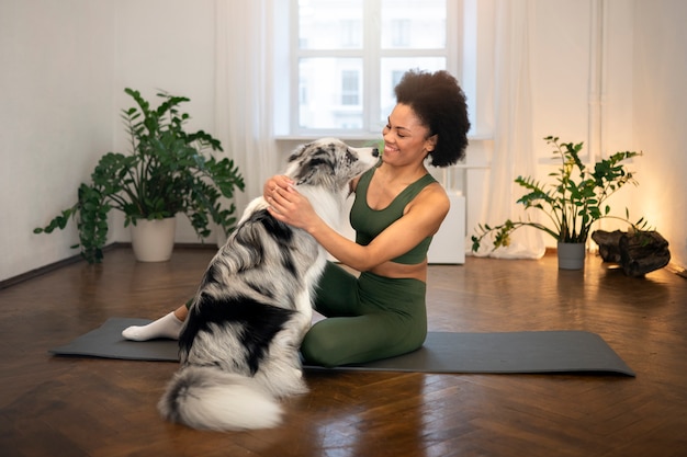 Mujer haciendo yoga acompañada de su mascota