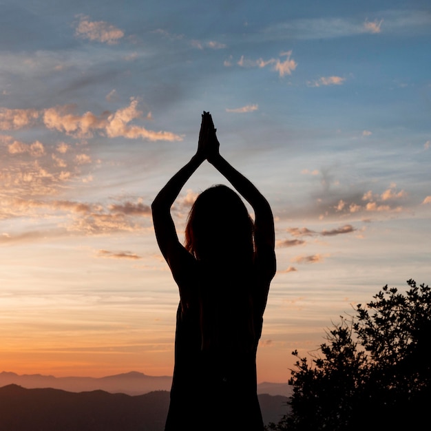 Mujer haciendo yoga al atardecer