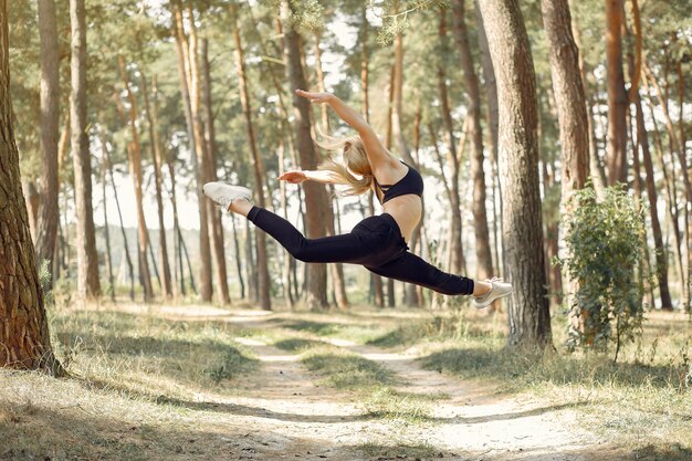 mujer haciendo yoga en un bosque de verano