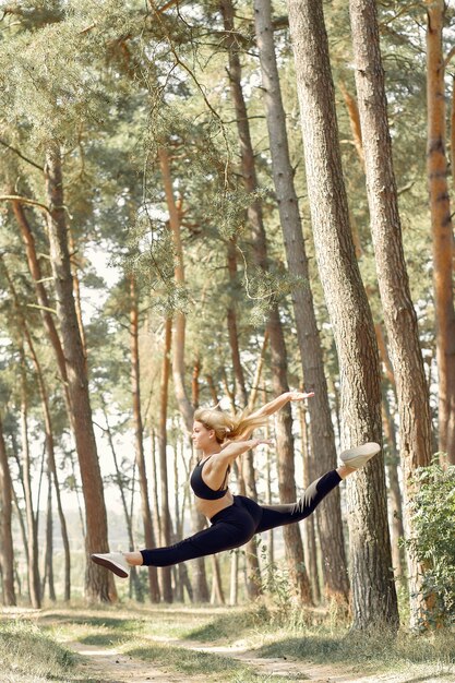 mujer haciendo yoga en un bosque de verano