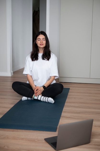 Mujer haciendo yoga en casa durante la cuarentena