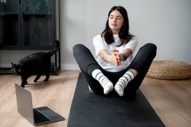 Mujer haciendo yoga en casa durante la cuarentena