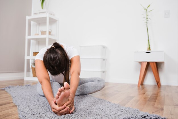 Mujer haciendo yoga en casa