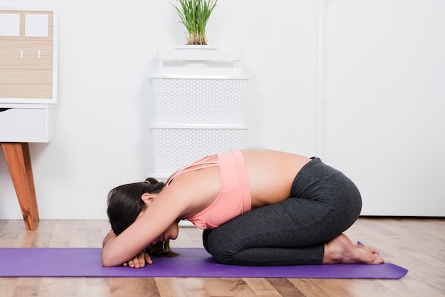 Mujer haciendo yoga en casa