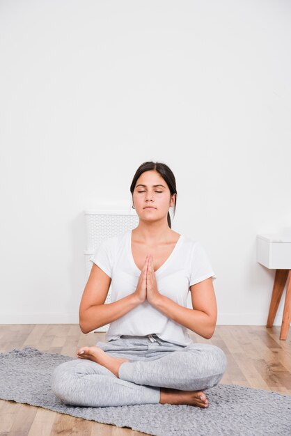 Mujer haciendo yoga en casa