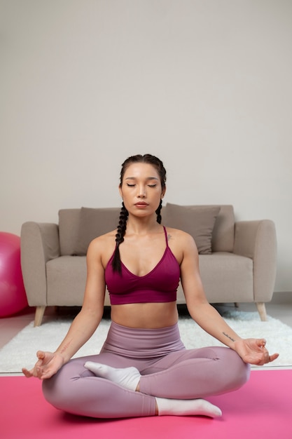 Mujer haciendo yoga después de instructor de fitness en línea