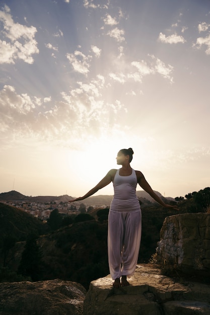 Mujer haciendo yoga en la montaña