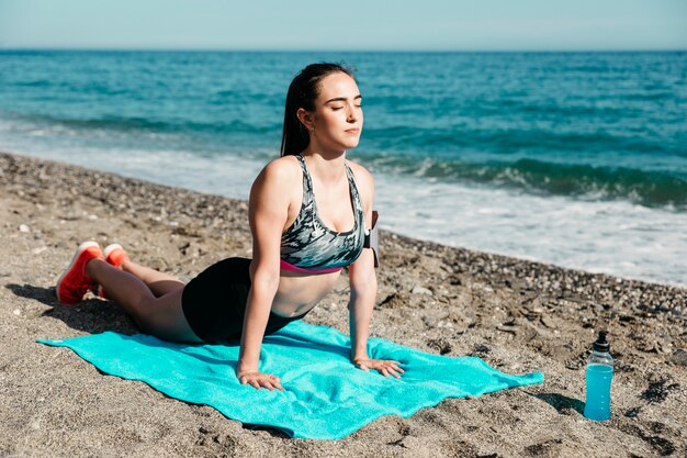 Mujer haciendo yoga en la playa