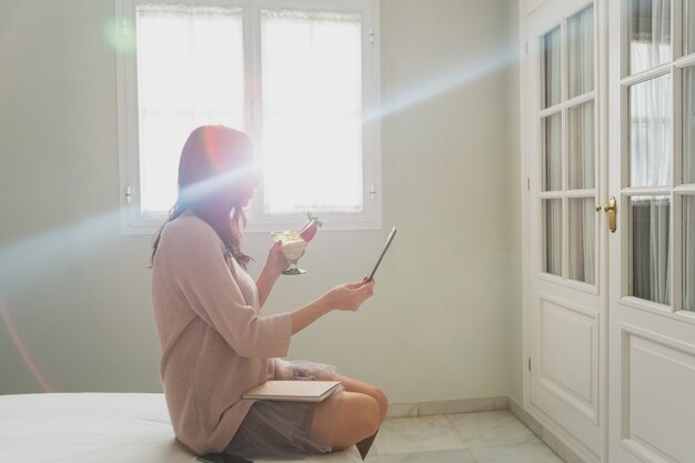 Mujer haciéndose una foto mientras sujeta un cóctel