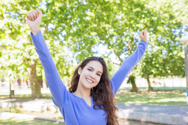 Mujer hermosa alegre que se extiende al aire libre