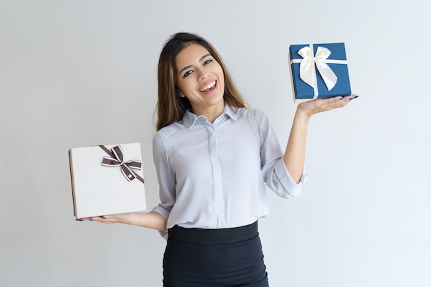 Mujer hermosa alegre que sostiene dos cajas de regalo