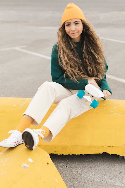 Foto gratuita mujer hermosa de alto ángulo con patineta