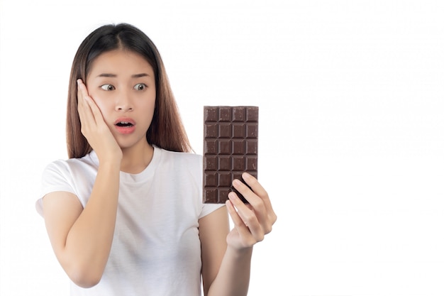 Mujer hermosa asiática con una sonrisa feliz que sostiene un chocolate de la mano