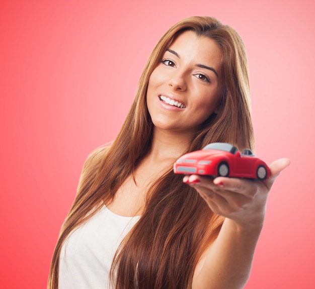 Mujer hermosa y coche de juguete.