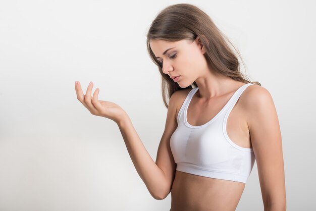 Mujer hermosa con el cuerpo sano en el fondo blanco