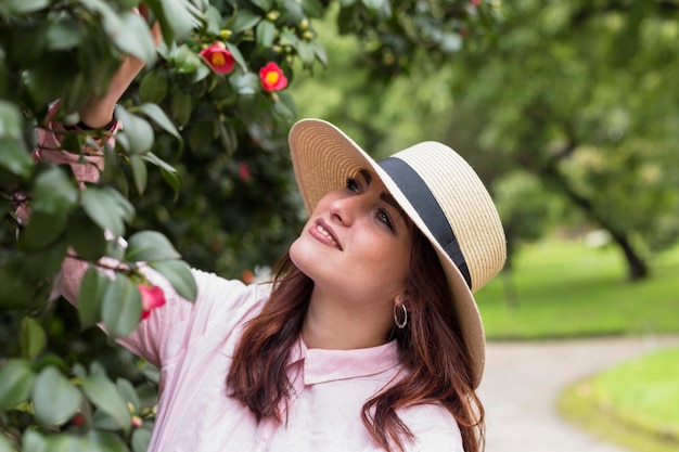 Mujer hermosa debajo del árbol floreciente en parque