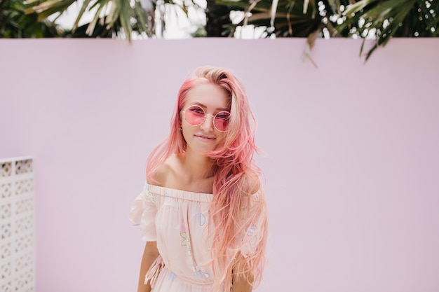 Mujer hermosa delgada con cabello largo rosa con sonrisa suave.