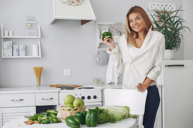 Foto gratuita mujer hermosa y deportiva en una cocina con verduras