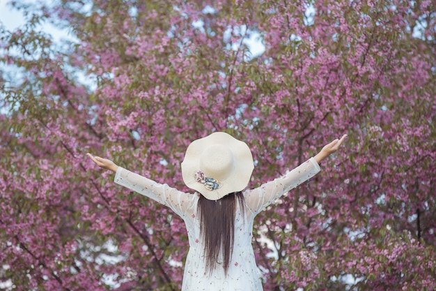 Una mujer hermosa y feliz estaba afuera con la mente abierta y miraba al cielo.