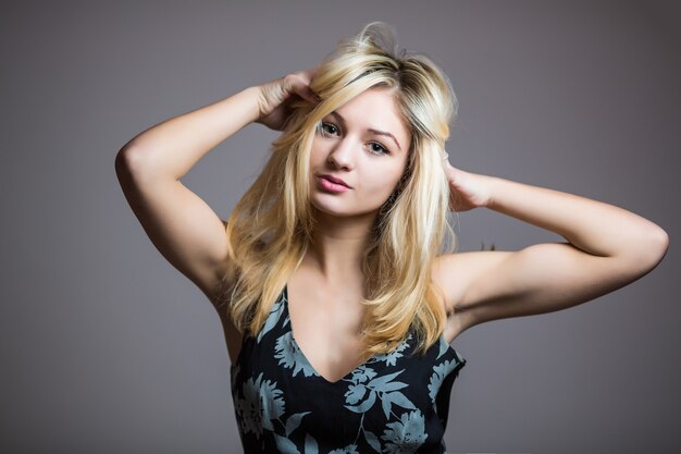 Mujer hermosa guapa muy sonriente aislada contra la pared en blanco del estudio.