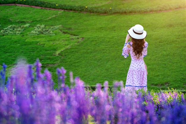 Mujer hermosa en un jardín de flores.