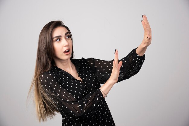 Mujer hermosa joven alejando las palmas de las manos mostrando rechazo y negación.