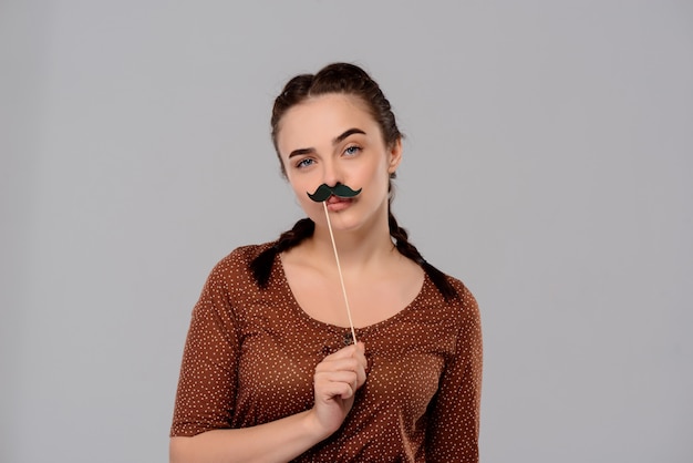 Foto gratuita mujer hermosa joven con bigote falso sobre pared púrpura