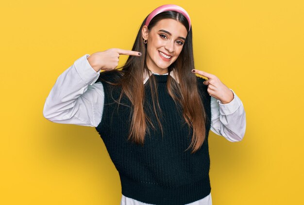 Mujer hermosa joven con camisa blanca casual sonriendo alegre mostrando y señalando con los dedos los dientes y la boca concepto de salud dental