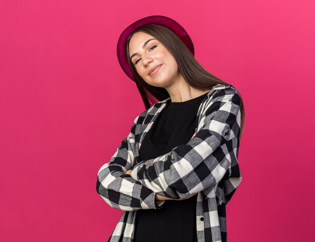 Mujer hermosa joven complacida con sombrero cruzando las manos