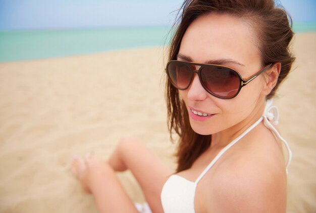 Mujer hermosa joven divirtiéndose en la playa