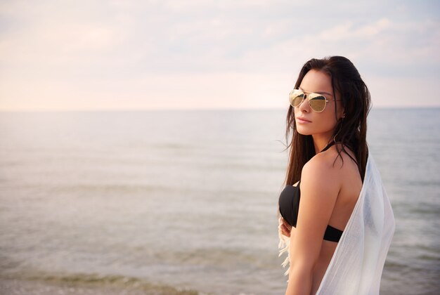 Mujer hermosa joven divirtiéndose en la playa