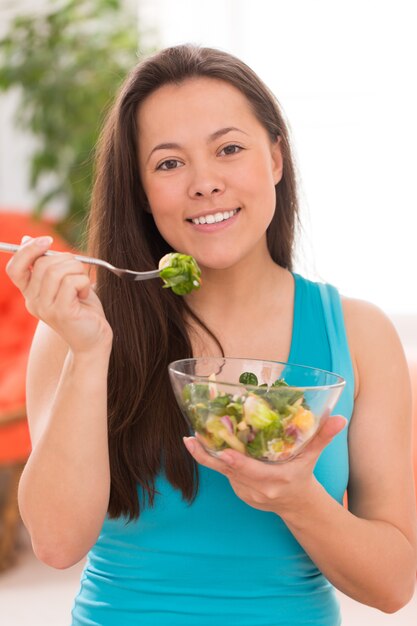 Mujer hermosa joven con ensalada