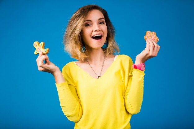 Mujer hermosa joven inconformista, comiendo galletas