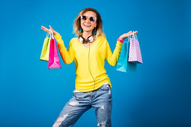 Mujer hermosa joven inconformista, sosteniendo bolsas de papel de colores