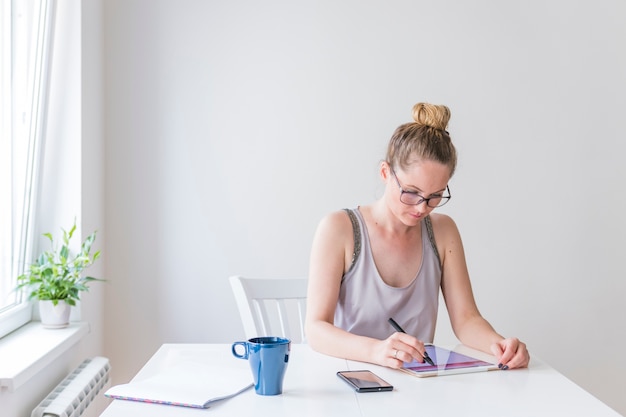 Mujer hermosa joven con lápiz sobre tableta digital gráfica