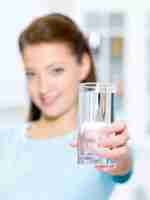 Foto gratuita mujer hermosa joven muestra un vaso de agua