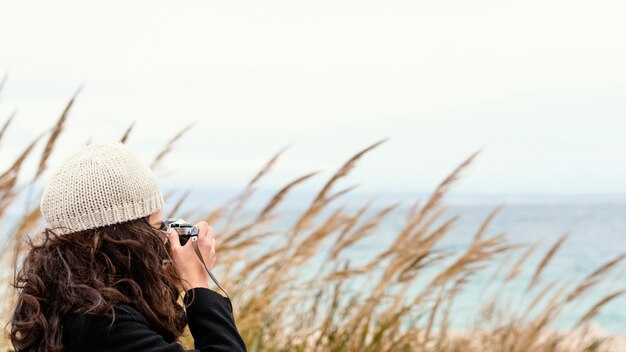 Mujer hermosa joven en la naturaleza con cámara