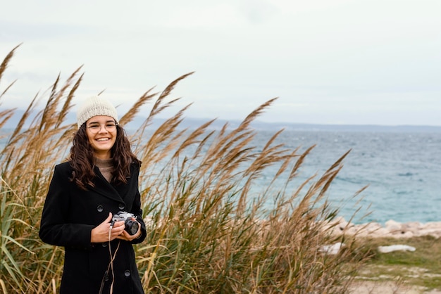 Mujer hermosa joven en la naturaleza con cámara