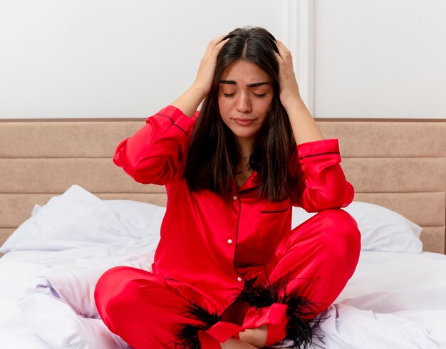 Foto gratuita mujer hermosa joven en pijama rojo relajante en la cama