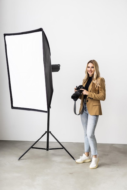 Mujer hermosa joven posando para una sesión de fotos en un estudio un fotógrafo está disparando con una cámara digital