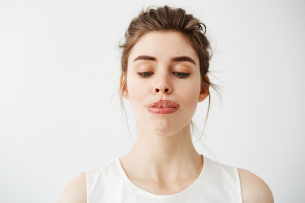 Mujer hermosa joven que estira la lengua a la nariz.