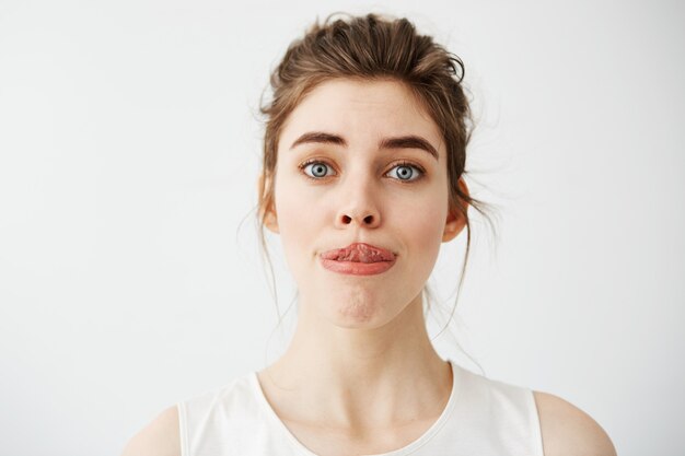 Mujer hermosa joven que estira la lengua a la nariz.